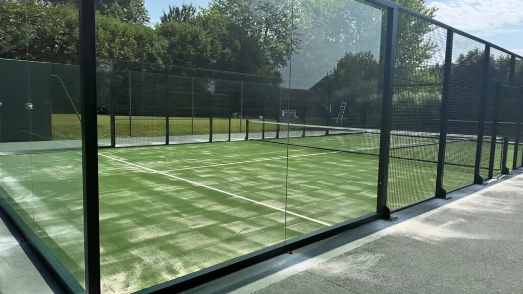 Terrain de padel panoramique construit par Padelcourt, chez un particulier du Calvados (14) : Le terrain vu à travers le vitrage latéral