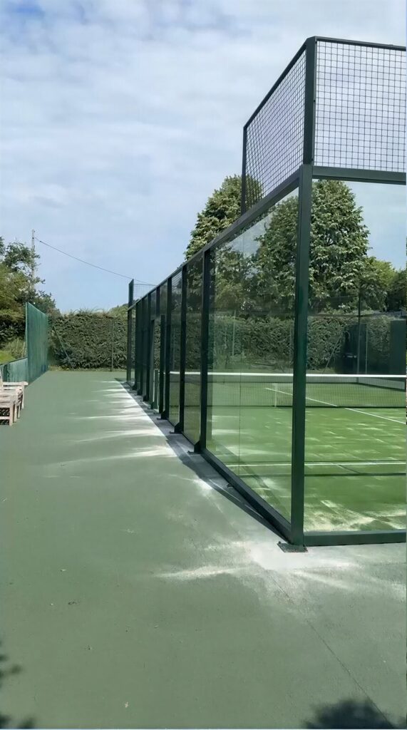 Terrain de padel panoramique construit par Padelcourt, chez un particulier du Calvados (14) : La piste posée sur l'ancien court, vitrage et grillage en partie haute